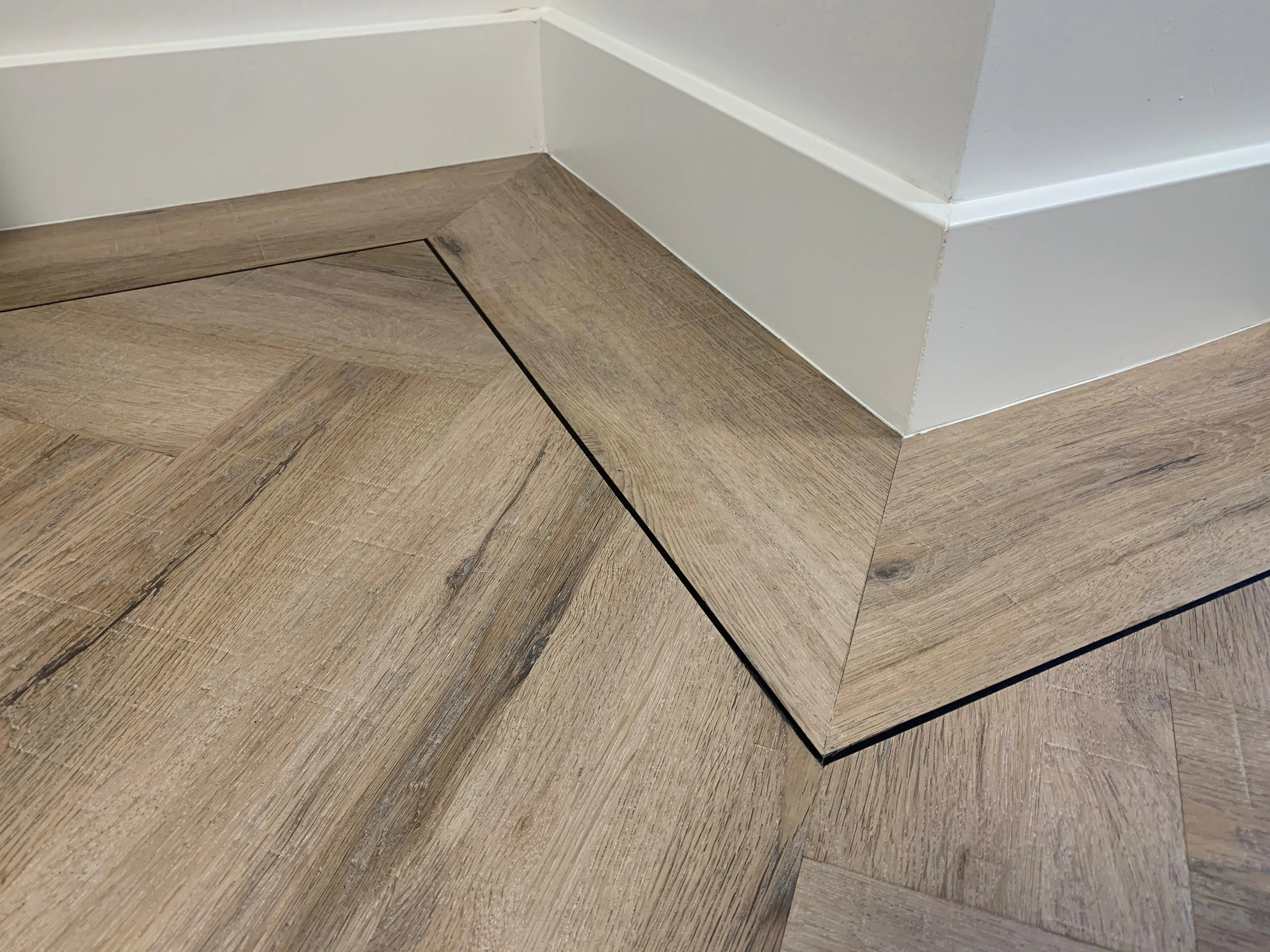 Gelasta City Visgraat 4700 Close-up van houtdessin Smoked Oak Light visgraat plak pvc met verfijnde afwerking