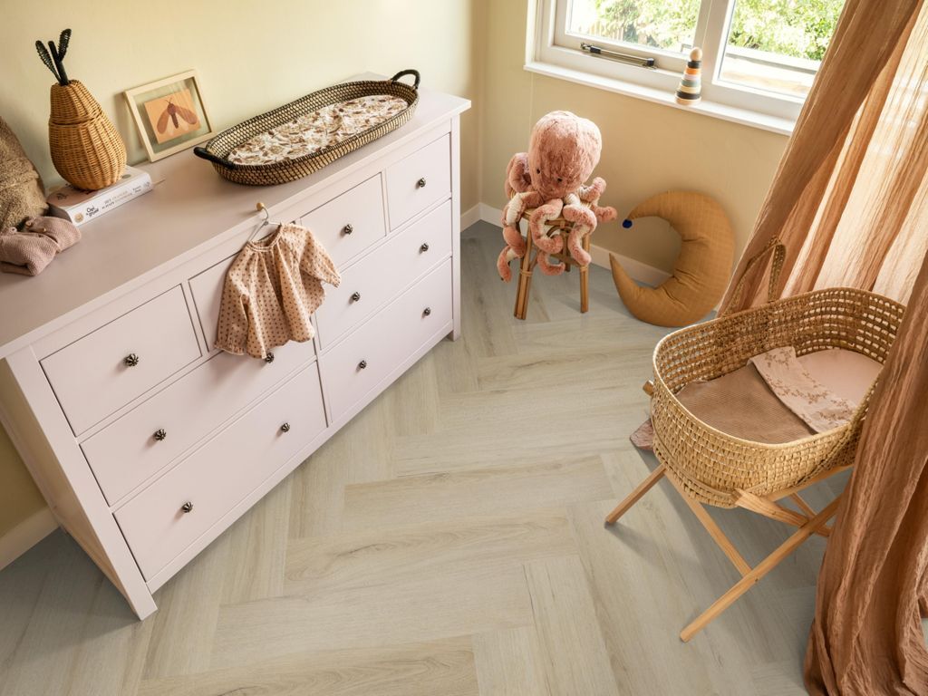 Ambiant Spigato XL Valento Visgraat 6080.1014.19 Smoky visgraat plak pvc in lichte babykamer met witte commode en rotan wieg