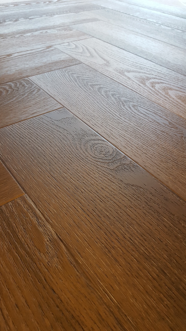 Ambiant Spigato Avanto Visgraat 9096.3501.19 Close-up van houtdessin Warm Brown visgraat plak pvc met natuurlijke tekening